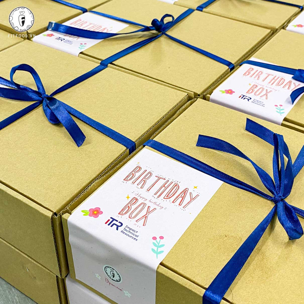 Hình phần ăn được đóng gói trong hộp carton có thắt nơ màu xanh nước